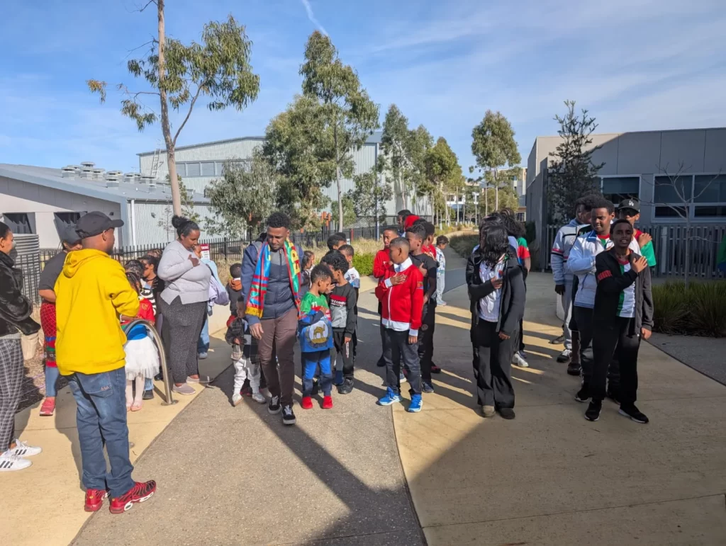 Children and families gathered outside the school building before an ELSP session