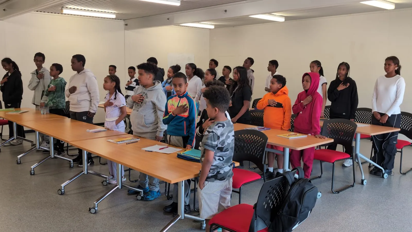 Students standing beside long tables at the start of an ELSP class