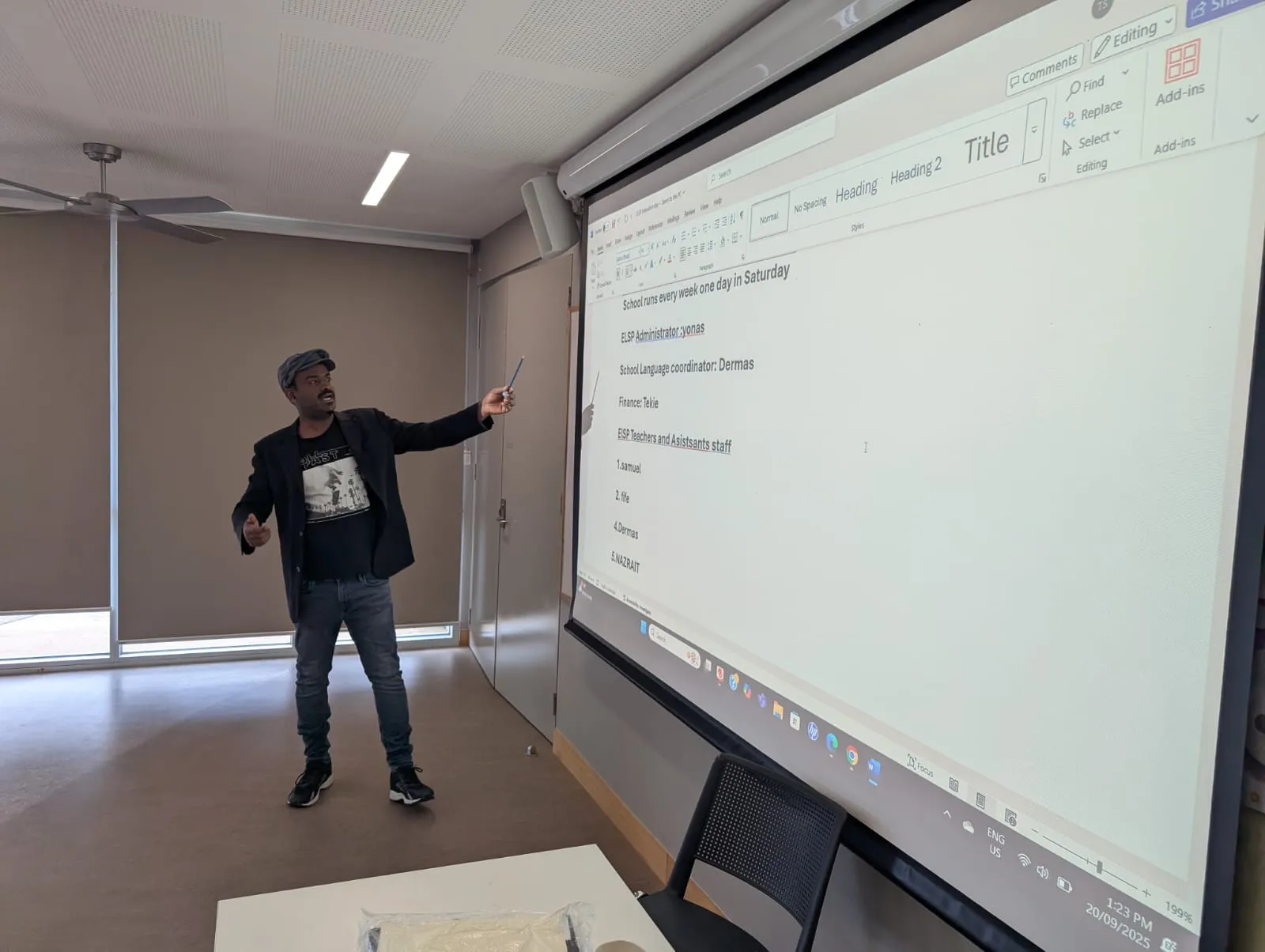 An ELSP coordinator presenting the program’s Saturday schedule and teaching staff on a large screen