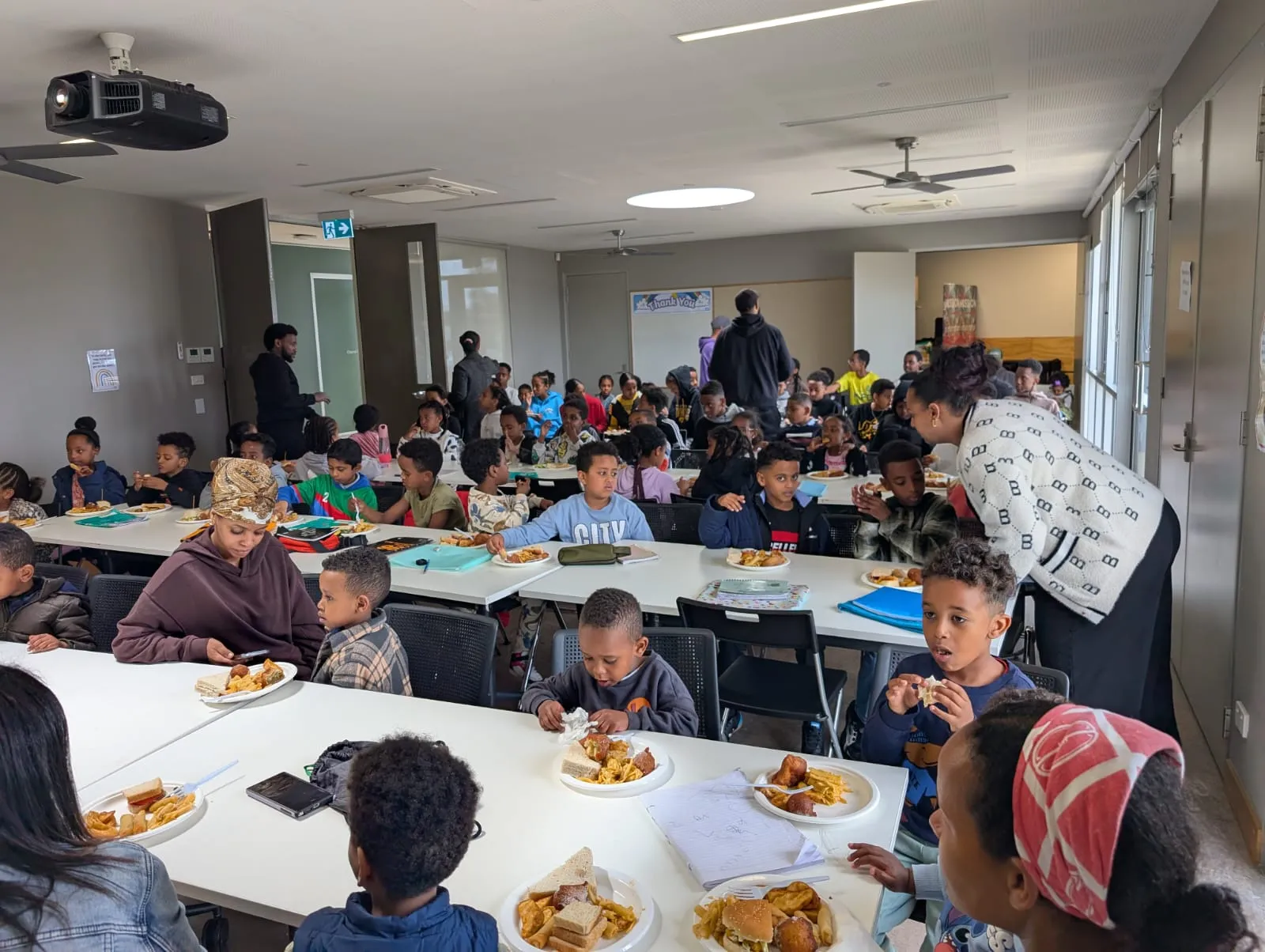 Children sharing a meal together at long tables during an ELSP event